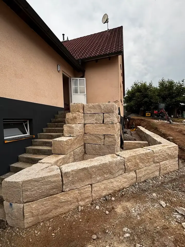 Fertige Natursteinmauer aus Jura-Quadern mit Treppe