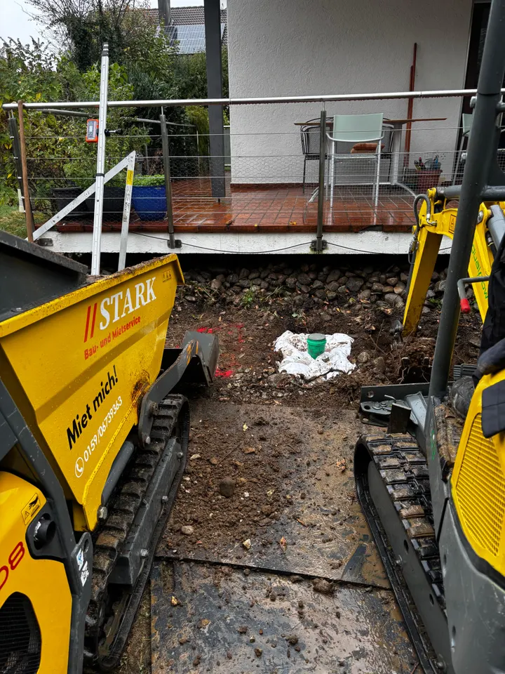 Stark-Kettendumper und Minibagger an der Baugrube für das Wärmepumpenfundament